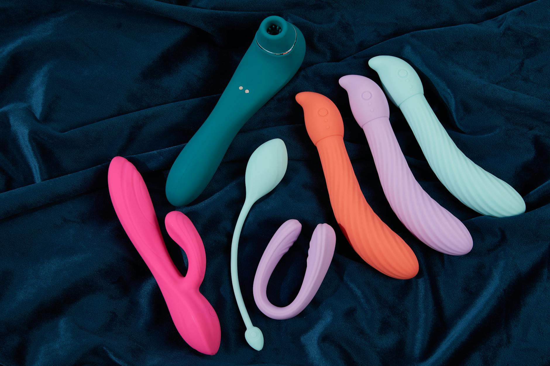 A stylish teal lemon clitoral vibrator on smooth white silk fabric