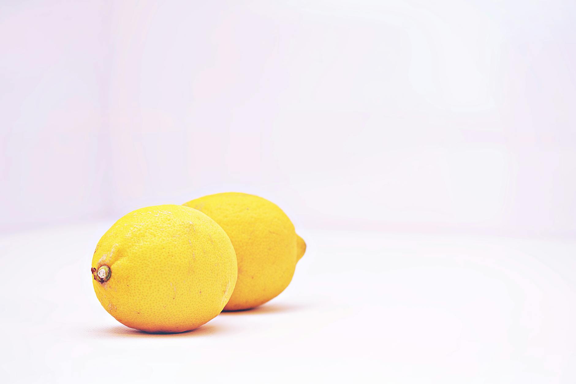 Close-up of a hand holding an orange vibrator against a minimalistic purple backdrop, symbolizing modern solo pleasure.