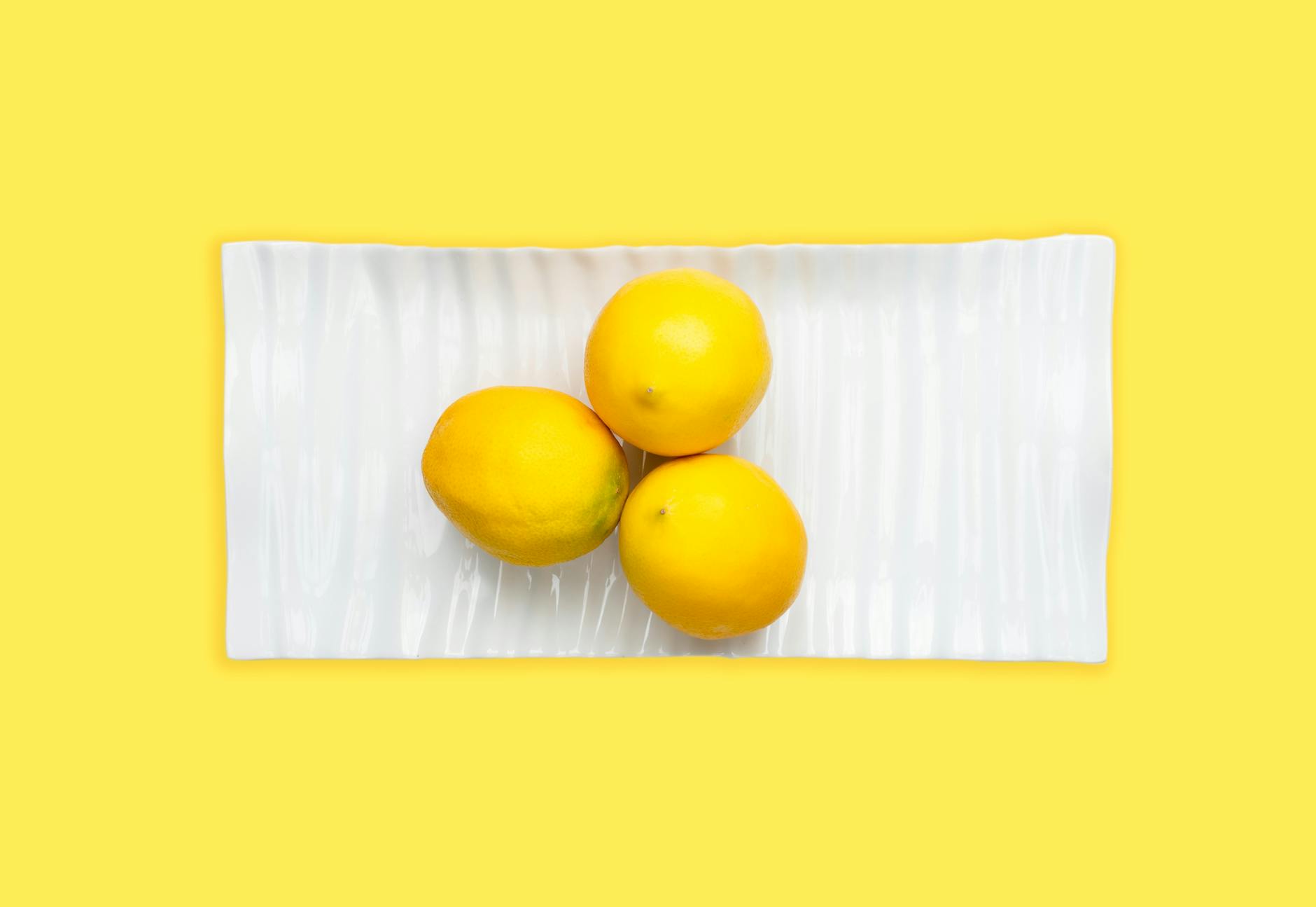 A yellow silicone vibrator surrounded by peeled bananas on a bright yellow background, symbolizing gentle pleasure during recovery.