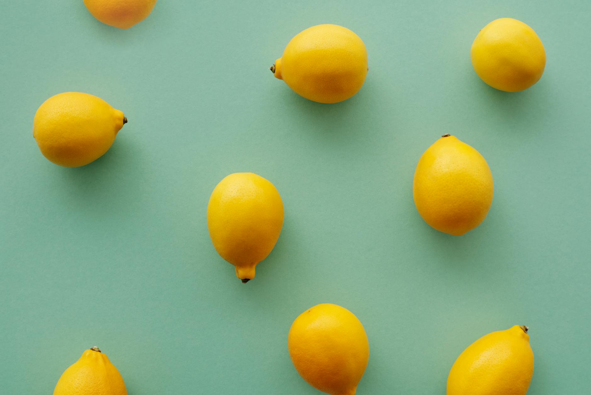 Bright yellow lemons arranged on a pastel green background, symbolizing the freshness and intensity you want to maintain with your lemon vibrator experience