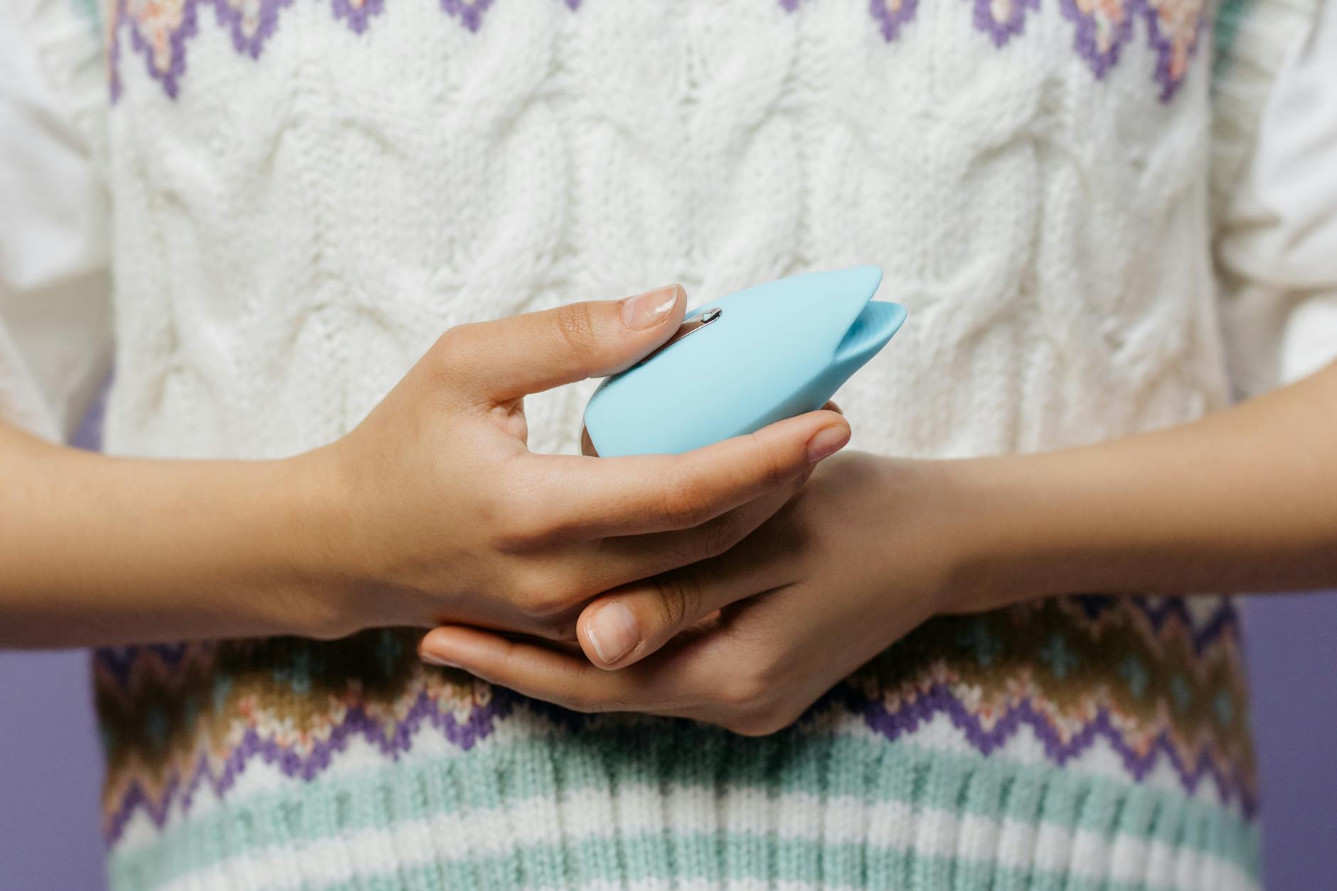 Two people holding clitoral vibrators together in thoughtful exploration