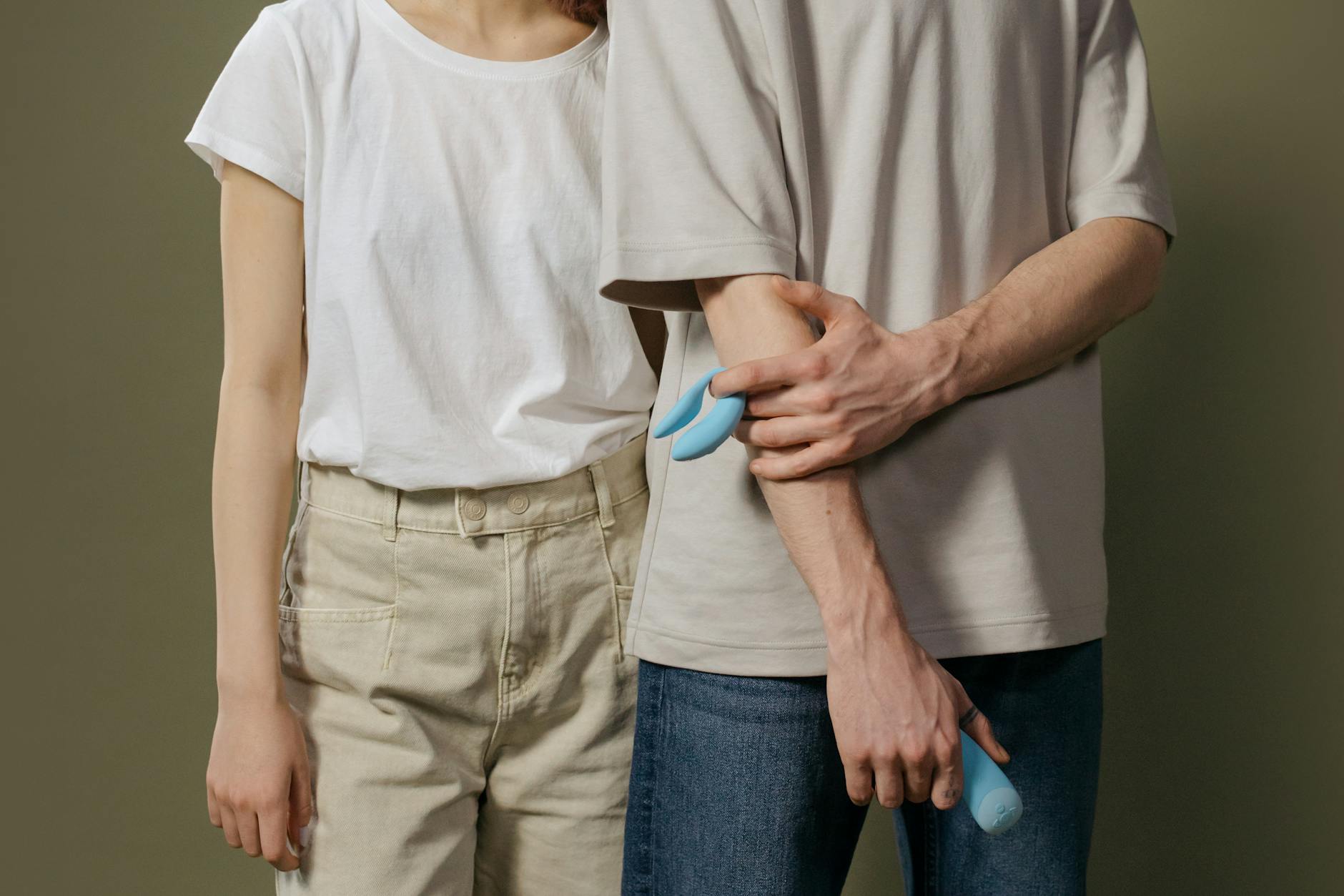 A young couple standing together indoors, exploring intimacy together with a modern vibrator