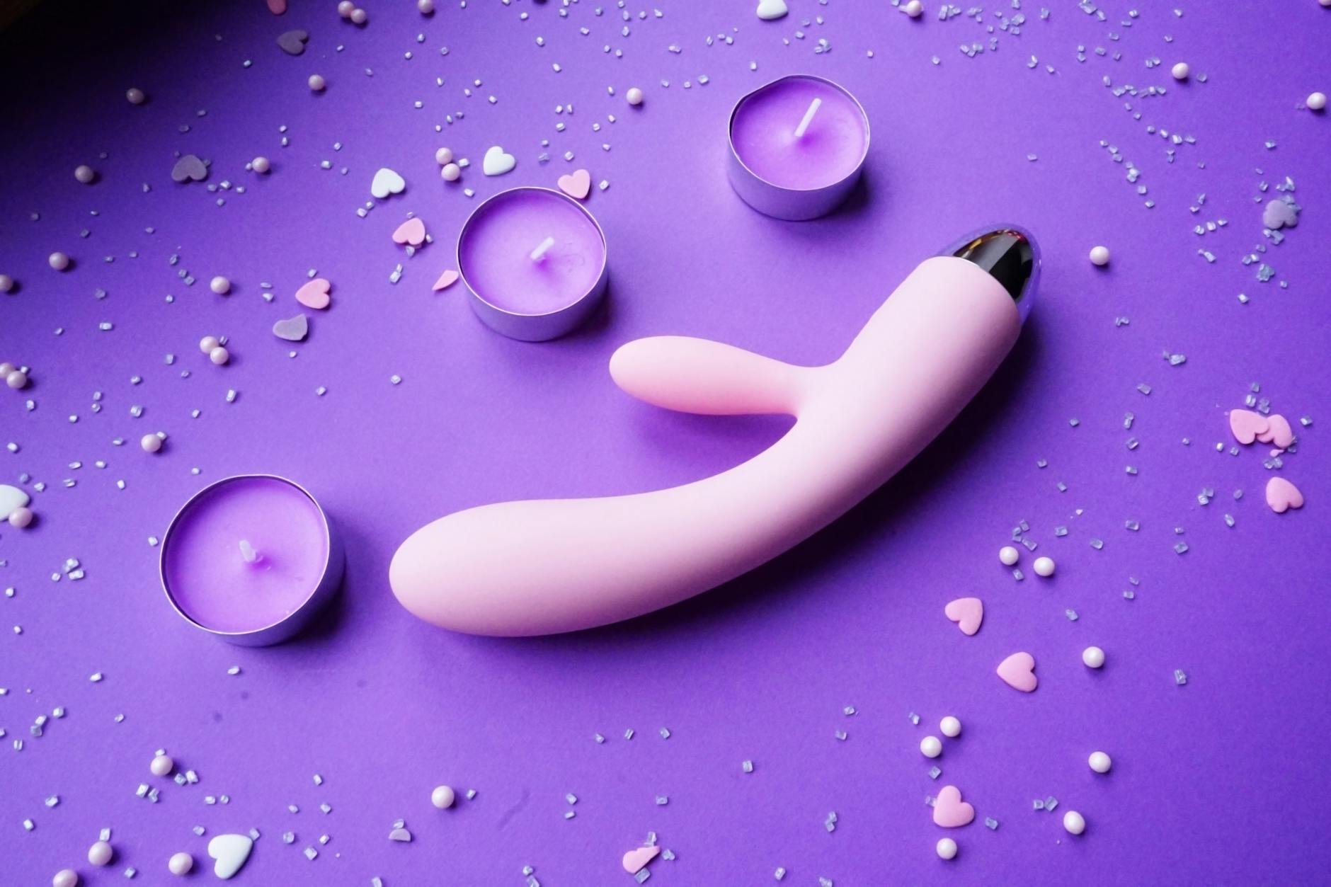 Pink lemon vibrator on purple background with romantic lighting