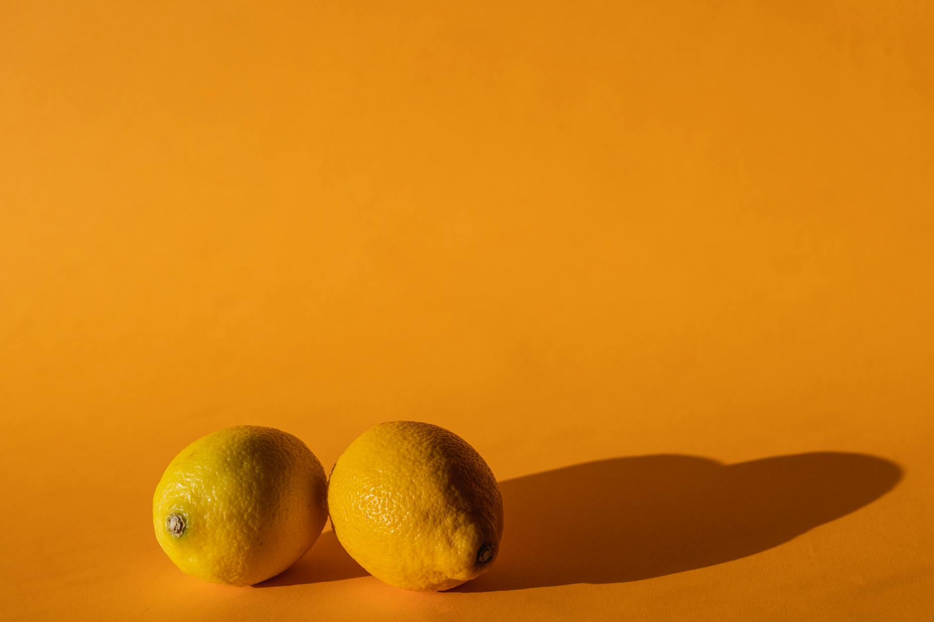 Bright lemons arranged on a yellow background, representing the Lemon vibrator from Hello Nancy